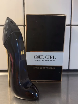 Good Girl parfym från Carolina Herrera - Good Girl från Carolina Herrera i en ikonisk flaska formad som en högklackad sko. Flaskan är svart med gulddetaljer och har en elegant, lyxig design. Kommer med originalkartong i svart och guld. Perfekt för dig som gillar exklusiva dofter.