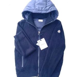 Mörkblå cardigan från Moncler - Snygg mörkblå dunväst från Moncler med stickade sidor och ribbade muddar jackan är perfekt nu för det kyligare vädret som kommer i höst. Äkta såklart. Priset är inte hugget i sten vid snabb affär. Hör av dig vid minsta lilla intresse L passar M