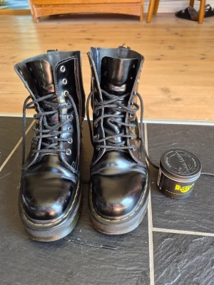 Svarta Dr. Martens kängor i läder - Ett par rejäla dr martens kängor med dubbel sula som isolerar mot kyla på vintern. Dessa har använts 4 vintrar I rad och har därför några små skavanker men jag har tagit hand om dom mycket väl! Dom är nyrengjorda, insmorda och sulorna är omhändertagna. Det ingår även ett vax jag köpt i dr martens butiken som man ska smörja skorna med var tredje månad.