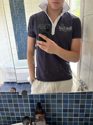 Scotch & Soda pike - Säljer en mörkblå Scotch & Soda t-shirt med vit knappslå och tryck på bröstet. Perfekt för sommaren om du vill ha en norsk/seglarstil. Exceptionell passform, därav priset. Nypris okänt, men svår att få tag på, vilket gör den unik.