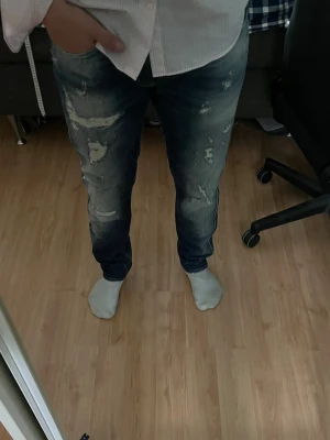 Replay Anbass jeans  - Säljer ett par blå jeans från Replay med snygga slitningar. Längd 104cm, midja 44,5cm. Jeansen saknar L storleken men den bedöms till L32 (utgå från måtten) JAG SKICKAR EJ FLER BILDER PÅ JEANSEN! för storleksguide hänvisar jag till måtten och för bättre inblick i passformen rekommenderar jag att googla på modellnamnet.JAG TAR EJ EMOT RETURER. kom ej med bud om du ej köper efter:) 