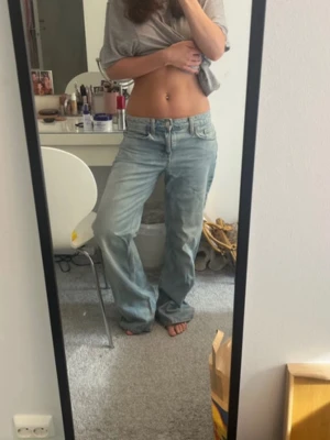 Ljusblå baggy jeans med raka ben och låg midja - Säljer ett par ljusblå lågmidjade jeans med avslappnad, baggy passform och raka ben. Slitna nere vid fötterna men annars i topp skick!