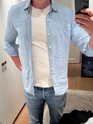 Uniqlo linneskjorta  - Ljusblå linneskjorta från uniqlo mycket bra skick och inte mycket använd. 