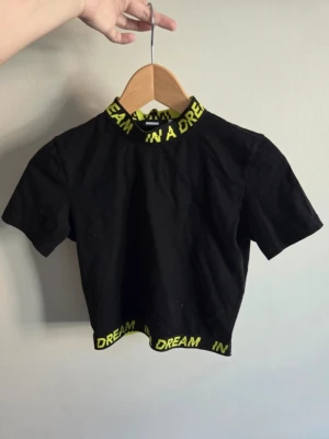 🖤 Trendig svart crop-top/magtröja med neongröna detaljer💚 - Trendig crop top med sportig look och textdetaljer vid halsringning och nederkant ✨ Perfekt att matcha med jeans, cargobyxor eller kjol för en avslappnad men stilren outfit 💚  ⚠️ Lättare bruksspår/ojämnheter i tyget förekommer på fram-, sida och baksida (se bild 5–7). Påverkar inte passform eller användning.  🖤 Storlek: S 🖤 Skick: Bra använt skick 🖤 Färg: Svart med neongröna detaljer  💌 Skriv gärna vid frågor  ⚠️ OBS: Alla plagg granskas noga innan försäljning, men mindre skavanker kan missas.
