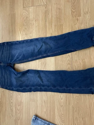 Mörkblå jeans från Gina Tricot - Säljer ett par mörkblå jeans från Gina Tricot i klassisk rak/ bootcut modell. Jeansen är i strl 158 men passar även folk i xxs/xs. Jeansen har  fickor, bälteshällor och kontrastsömmar. Perfekta till vardags och lätta att matcha med olika stilar.