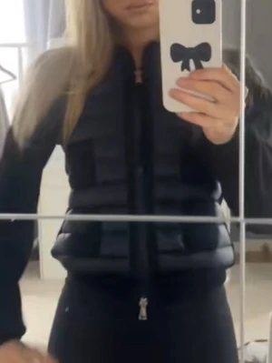 Svart moncler jacka - Snygg svart dunväst med quiltad design och dragkedja framtill. Västen har en modern, puffig look och passar perfekt över en hoodie eller tröja. Enkel och stilren modell som ger en sportig vibe. Pris går att diskutera 
