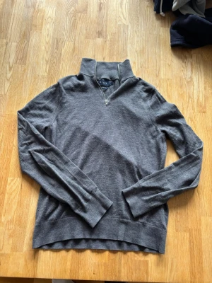 Grå merinoulltröja från Riley - En liten tunnare mörkgrå zip. Passar bra som casual plagg men även till mer uppklädda tillfällen. Andvänd endast 3 gånger. 1000 kr nypris. 