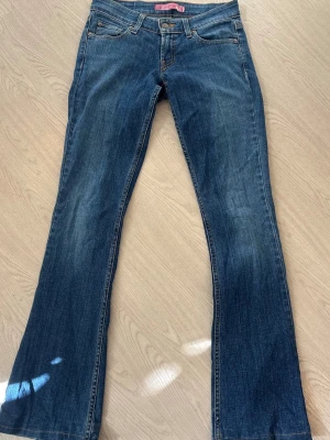 Lågmidjade jeans - Säljer dessa fina lågmidjade och utsvängda jeans från Levis. Dom har inga defekter förutom att dom är lite slitna längst ner. Mått: längd 80cm och midja rakt över ca 35 cm. Dom är lite stretchiga. Skriv om ni har frågor!😊