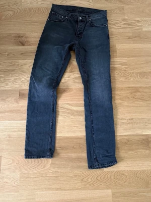 Mörkgrå Nudie jeans Grim Tim - Mörkgrå Nudie Jeans Grim Tim i storleken 31/32. Hör av dig ifall du har funderingar. Priset ej hugget i sten!