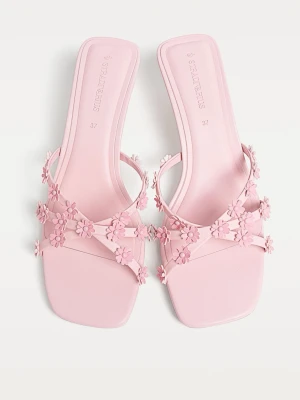 Rosa Kitten heels med blommor  - Säljer ett par ljusrosa Kitten heels från Stradivarius med små 3D-blommor på remmarna. De har en låg klack och fyrkantig tå, vilket ger en trendig look. 