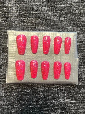Press-on naglar || storlek M - Säljer ett set press-on naglar i neonrosa med glittriga inslag och holografiska flakes. Naglarna har en rak, något avsmalnande form och är perfekta för dig som vill sticka ut. Storlek M, Det du får med dig : * Fil och manikyr pinne * nagellim klistermärken * 2 lappar av rengöring för naglar.