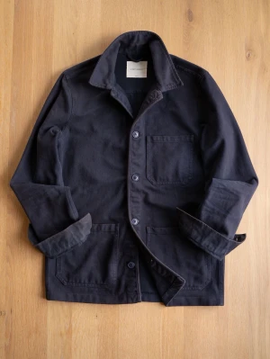 Marinblå overshirt från A Day's March - Stilren svart overshirt från A Day's March i kraftig bomull. Klassisk krage, tre stora utanpåfickor och knäppning framtill. Perfekt lager-på-lager-plagg med avslappnad passform och snygga detaljer.