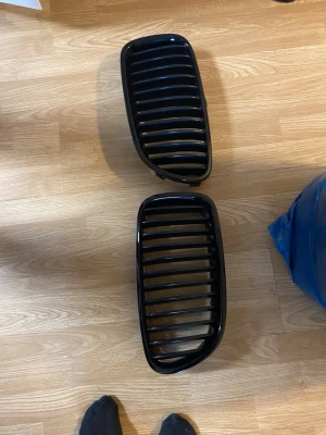 Svarta grillgaller till bil BMW f10 original - Säljer ett par svarta grillgaller till bil, troligen till BMW. De har en klassisk njurform och är tillverkade i plast med glansig finish. Perfekt för dig som vill ge bilen en sportigare look.