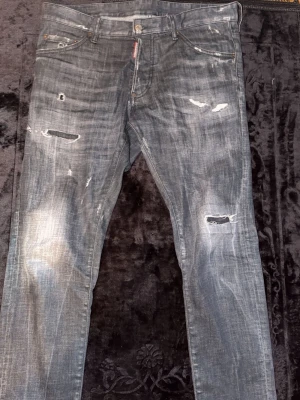 Äkta Svarta/gråa Dsquared jeans size 48/50 - Säljer ett par Dsquared Jeans som är köpta några månader sedan. Finns bevis på äkthet. Size 50 men passar till folk som har 48. Vid mer frågor bara hör av er.