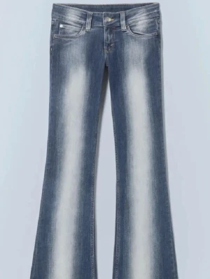 Weekday blå utsvängda jeans med blekta partier - Säljer ett par blå jeans med utsvängda ben och tydliga blekta partier framtill. Klassisk femficksmodell med knapp och dragkedja. 💓💓