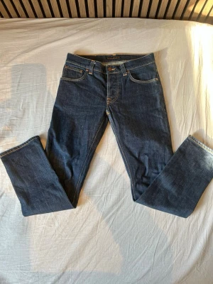 Mörkblå Nudie Jeans Grim Tim  - Helt nya Nudie Jeans i modellen Grim Tim, som är en slim fit och färgen dry open navy. Jeansen är aldrig använda och bara testade. Säljs på grund av de var förstora gör mig. Hör av er vid någon fråga eller fundering. Pris kan diskuteras vid snabb och smidig affär✅