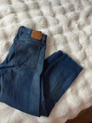 Levi's strauss blå raka jeans vintage byxor denim S  - Säljer ett par klassiska blå Levi's jeans med raka ben och hög midja. Jeansen har den ikoniska läderlappen bak och Levi's röda etikett på bakfickan. Tillverkade i slitstark denim med snygga kontrastsömmar. Perfekta för en avslappnad och tidlös stil.