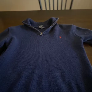 Mörkblå tröja från Polo Ralph Lauren - Säljer en snygg mörkblå tröja från Polo Ralph Lauren i storlek M i barnstorlek. Perfekt för höst och vinter, och den är i mycket bra skick. Passar både till vardags och lite finare tillfällen.