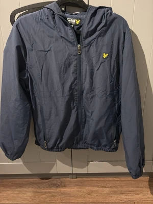 Lyle & Scott jacka - Snygg marinblå vindjacka från Lyle & Scott med dragkedja framtill! Använd ytterst få gånger!  Xs