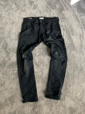 Mörkblå slim fit jeans från Jack and Jones - Snygga mörkblå slim fit jeans från Jack and Jones med klassisk femficksdesign och knappgylf. Jeansen har en smal passform och är tillverkade i stretchigt denimtyg för extra komfort. Perfekta för en trendig och avslappnad look. Hör av dig vid minsta fundering eller fråga och pris kan diskuteras! 💯😁