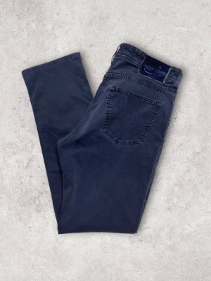 Mörkblå jeans från Jacob Cohen - Snygga mörkblå jeans från Jacob Cohen med klassisk femficksmodell och raka ben. Jeansen har en diskret logga på bakfickan och patch i midjan. Tillverkade i mjukt denimtyg som ger en skön känsla och stilren look. Mörkblå/grå färg