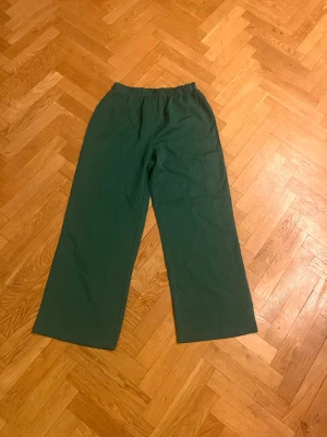 Gröna vida mjukisbyxor - Mörkgröna mjukisbyxor med breda ben och resår i midjan. Byxorna har en enkel och clean design utan synliga loggor eller detaljer. Perfekta för chill dagar hemma eller när du vill ha det bekvämt. Materialet känns mjukt och följsamt.Skriv gärna för mått! 💕