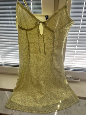 Gul sommarklänning  - Super gullig sommarklänning. Ljusgul med gula/gröna blommor på. Säljer då den inte används. Mini klänning perfekt till sommarn. Justerbara axelband. Skriv vid frågor. Pris kan diskuteras! ❤️