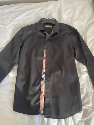 Burberry skjorta - Svart burberry skjorta aldrig använd storlek m passar slim fit. Skriv vid frågor.