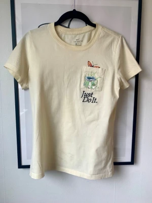 T-shirt - Nike - Ljusgul T-shirt med broderad detalj från Nike. Storlek S, men passar även en XS. I mycket fint skick 🌸