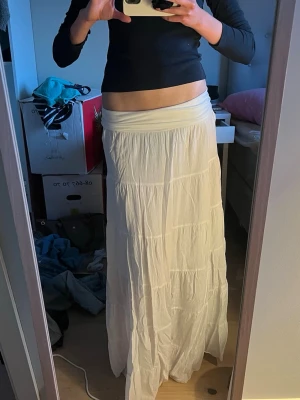 Vit långkjol vikbar midja  - Säljer en flowy vit långkjol, köpt i en butik i Frankrike. Passar perfekt på en storlek S men även M då den e töjbar 