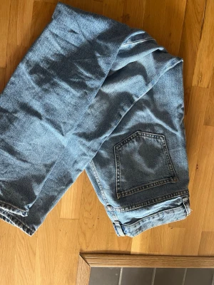 Blå raka jeans i klassisk modell - Säljer ett par blå jeans med rak passform och hög midja. Jeansen har en klassisk femficksdesign och är gjorda i slitstark denim. Perfekta till en avslappnad stil och passar till det mesta. Inga synliga loggor eller märken.