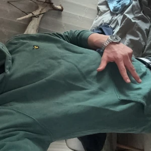 Grön hoodie från Lyle & Scott - Säljer en grön hoodie från Lyle & Scott. Jävligt skön dock lite knuvlig. Har typ aldrig använt den så den har bara legat ihop vikt