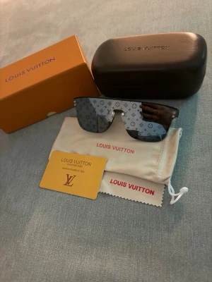 Louis Vuitton monogram solglasögon - Snygga solglasögon från Louis Vuitton med spegelglas och ikoniskt monogrammönster över hela linsen. Sköldpaddsinspirerad båge och stor, rektangulär form. Kommer med originalfodral, putsduk och box.