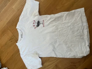 Vit t-shirt från Vans - Vit t-shirt från Vans med tryck på både fram- och baksidan. Storlek xs men den är ganska owersized 