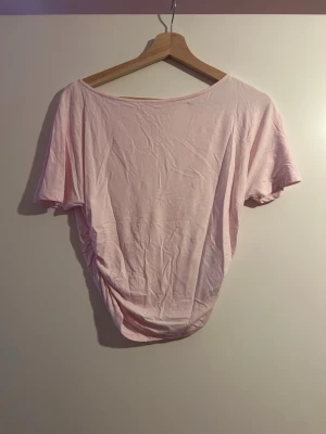 Ljusrosa t-shirt från Gina Tricot - En enkel och snygg ljusrosa t-shirt från Gina Tricot i storlek XS. T-shirten har korta ärmar och är tillverkad i mjuk bomull, perfekt för en avslappnad och trendig look. Passformen är normal och färgen är riktigt fräsch.