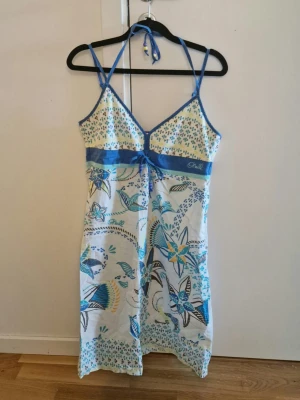 Y2K Sommarklänning - Tunn strand/sommarklänning från O'Neill. Har dragkedja vid sidan och justerbara axelband med knyt i nacken. 