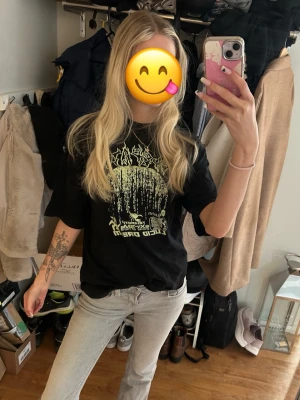 Svart oversized t-shirt med tryck - Cool svart oversized t-shirt med stort grafiskt tryck i neonfärg på framsidan. T-shirten har rund hals och korta ärmar, perfekt för en avslappnad och trendig look. Passar dig som gillar streetwear och vill sticka ut lite extra.