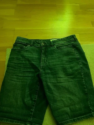 Mörkblå jeansshorts  - Snygga mörkblå jeansshorts i klassisk modell med fem fickor och rå kant nertill. Shortsen har normal passform och stängs med knapp och dragkedja. Perfekta för sommaren och passar till det mesta.