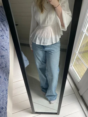 Låga ljusblå jeans - Ett par lågmidjade jeans ifrån Gina Tricot, storlek 38  Använda med tydligt slitage längst ner vid sömmen på benen, annars i bra skick