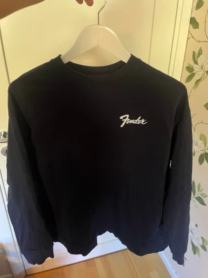  sweatshirt Zara x Fender - Cool  sweatshirt från samarbetet mellan Zara och Fender. Tröjan har rund halsringning, långa ärmar och en vit Fender-logga på bröstet. Perfekt för dig som gillar musik och streetstyle.