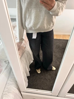 Svarta vida jeans med rak passform - Säljer ett par svarta jeans med rak och lite vidare passform. Jeansen har klassisk femficksdesign och är tillverkade i denim. Perfekta för en avslappnad och trendig stil.
