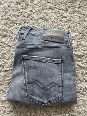 Gråa Replay jeans  - Snygga slitningar men ett litet hål som syns på bild 