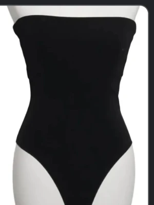 Svart tubbody i stretchigt material - Säljer en stilren svart body med tubmodell och högt skurna ben. Bodyn är tillverkad i ett stretchigt material som sitter tight mot kroppen och har en enkel, minimalistisk design utan axelband.