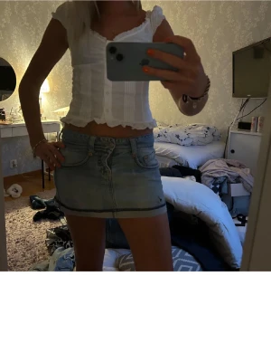 Ljusblå jeanskjol i kort modell - Trendig ljusblå jeanskjol i kort modell med klassiska fickor fram och bak samt bälteshällor. Kjolen har en rak passform och är perfekt för dig som gillar en avslappnad och cool stil.
