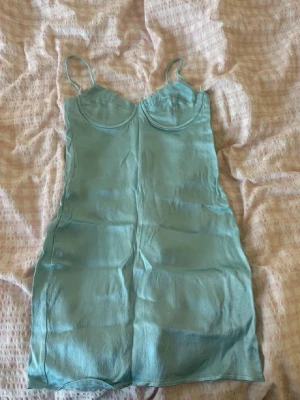 Satin klänning - Blå satin klänning Zara. Storlek s men väldigt liten i storleken. Byglarna sticker även ut men de kan man tejpa eller ta ut helt 