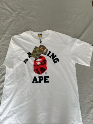 Bare t-shirt  - Säljer en vit vapen tröja med rött märke den är sprillans ny inte en enda skråma på den jag säljer den för att den är för liten på mig skick 10/10