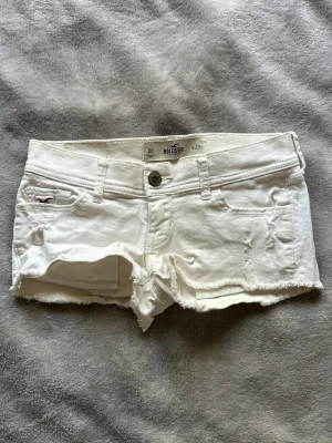 Vita korta lågmidjade hollister shorts XS 23 - Supersnygga shorts från Hollister i storlek 23. Mått finns i bilden. Passar tyvärr inte längre😢Bra skick, inga defekter!
