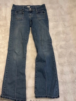 Blå bootcut jeans från Nelly - Säljer ett par blå bootcut jeans från Nelly med dubbla framfickor . Perfekta för dig som gillar en retroinspirerad look och vill ha ett par jeans som sticker ut lite extra. Jättefina och sköna! Se defekter på sista bilderna!❤️