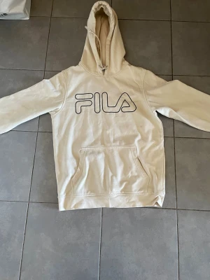 Beige Fila Hoodie  -  Det är en beige fil hoodie har varit använd några gånger acceptabelt skick och vi kan diskutera priset om ni vill .