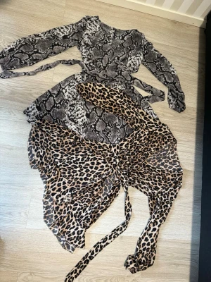 Klänning med ormmönster och leopard - Inga skador eller defekter. Klänningen har knytband i midjan. Orm mönster klänning XS och leopard antingen XS eller S. Båda för 80kr
